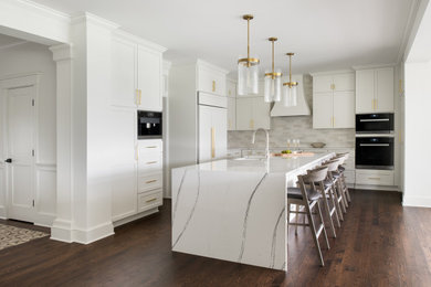 Example of a large trendy u-shaped dark wood floor eat-in kitchen design in Burlington with a farmhouse sink, shaker cabinets, white cabinets, quartz countertops, white backsplash, ceramic backsplash, an island and white countertops