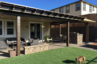 Patio kitchen - mid-sized traditional backyard brick patio kitchen idea in Other with a pergola