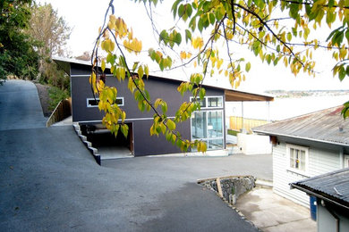 Photo of a mid-sized modern two-storey brown exterior in Wellington with wood siding and a shed roof.