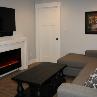 Family room - small beach style enclosed vinyl floor family room idea in Edmonton with gray walls, a ribbon fireplace, a wood fireplace surround and a wall-mounted tv