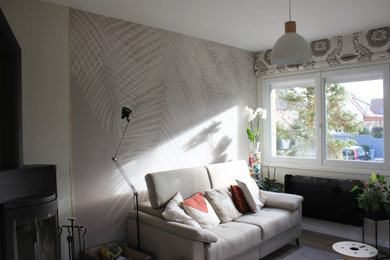 Aménagement d'un salon beige et blanc scandinave de taille moyenne et fermé avec un mur beige, parquet clair et du papier peint.