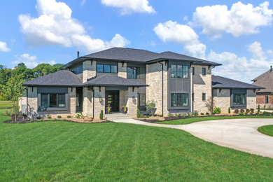 Example of a huge brown two-story stone and board and batten house exterior design in Indianapolis with a hip roof, a shingle roof and a black roof