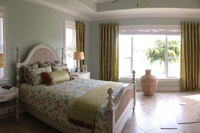 Mid-sized elegant master ceramic tile and beige floor bedroom photo in Miami with blue walls and no fireplace