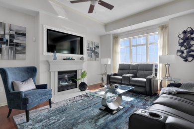 Photo of a mid-sized modern open concept living room in Jacksonville with white walls, medium hardwood floors, a standard fireplace and brown floor.