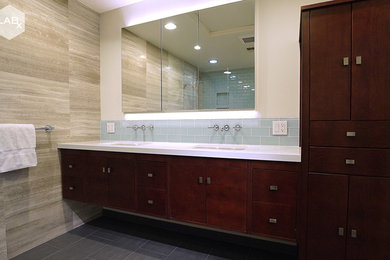 Example of a mid-sized minimalist master blue tile and glass tile porcelain tile corner shower design in San Francisco with flat-panel cabinets, medium tone wood cabinets, white walls, an undermount sink and quartz countertops