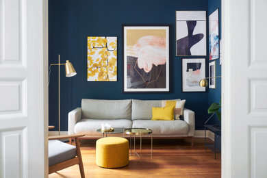 Modernes Wohnzimmer mit blauer Wandfarbe, braunem Holzboden und braunem Boden in Berlin