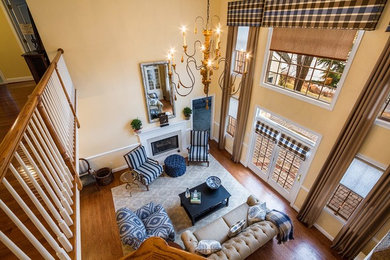 Example of a large open concept medium tone wood floor living room design in Philadelphia with yellow walls, a standard fireplace and no tv