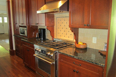 Eat-in kitchen - mid-sized traditional galley medium tone wood floor eat-in kitchen idea in Atlanta with a double-bowl sink, recessed-panel cabinets, dark wood cabinets, granite countertops, white backsplash, ceramic backsplash, stainless steel appliances and no island