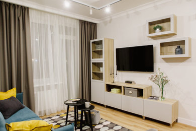 На фото: гостиная комната в современном стиле с бежевыми стенами, полом из керамической плитки, телевизором на стене, желтым полом, обоями на стенах и синим диваном с