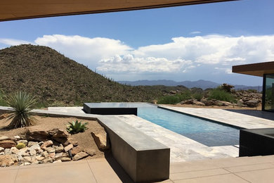 Inspiration for a large contemporary backyard stone and custom-shaped infinity pool fountain remodel in Phoenix