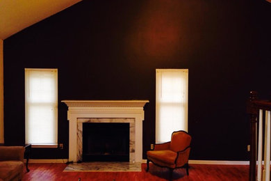 Fernseherloses Wohnzimmer im Loft-Stil mit brauner Wandfarbe, braunem Holzboden und Kamin in Raleigh