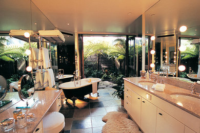 Klassisk inredning av ett stort badrum, med släta luckor, vita skåp, ett badkar med tassar, en dusch/badkar-kombination och ett undermonterad handfat