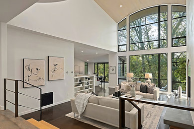 Large open concept brown floor living room photo in Seattle with white walls, a standard fireplace and a plaster fireplace