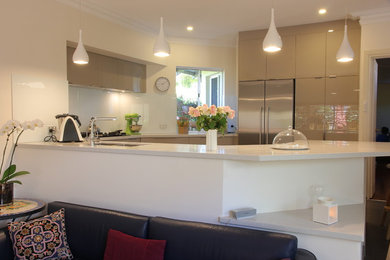 Photo of a medium sized modern kitchen in Perth with a submerged sink, engineered stone countertops, white splashback, glass sheet splashback, stainless steel appliances, grey floors and grey cabinets.