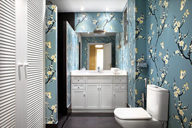 Modelo de cuarto de baño tradicional renovado con puertas de armario blancas, armarios con puertas mallorquinas, ducha empotrada, sanitario de una pieza, baldosas y/o azulejos negros, paredes multicolor, aseo y ducha, suelo negro, ducha abierta y encimeras blancas