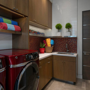 Immagine di una grande lavanderia multiuso minimal con lavello sottopiano, ante lisce, ante in legno scuro, top in quarzite, paraspruzzi rosso, paraspruzzi con piastrelle a mosaico, pareti bianche, pavimento in gres porcellanato, lavatrice e asciugatrice affiancate, pavimento grigio e top bianco