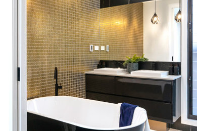 Inspiration for a contemporary bathroom in Sydney with flat-panel cabinets, black cabinets, a freestanding tub, black tile, a vessel sink, white floor, white benchtops, a double vanity and a floating vanity.