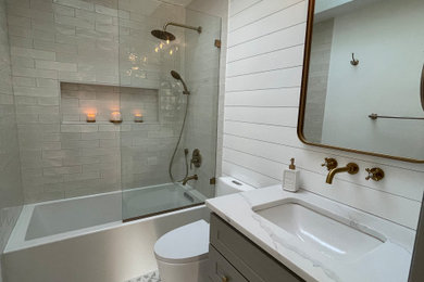На фото: маленькая главная ванная комната в классическом стиле с фасадами с утопленной филенкой, серыми фасадами, ванной в нише, душем, унитазом-моноблоком, белой плиткой, белыми стенами, полом из керамической плитки, накладной раковиной, столешницей из гранита, разноцветным полом, белой столешницей, нишей, тумбой под одну раковину и напольной тумбой для на участке и в саду с