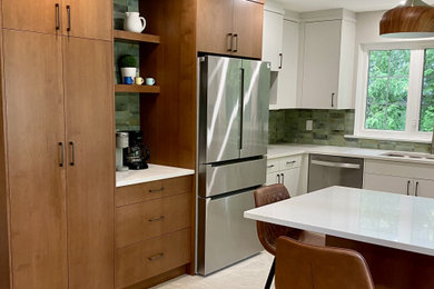 Example of a mid-sized mid-century modern u-shaped porcelain tile eat-in kitchen design in Toronto with an undermount sink, flat-panel cabinets, quartz countertops, green backsplash and stainless steel appliances