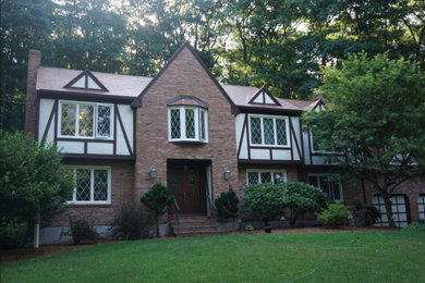 Large elegant two-story brick exterior home photo in Boston with a metal roof