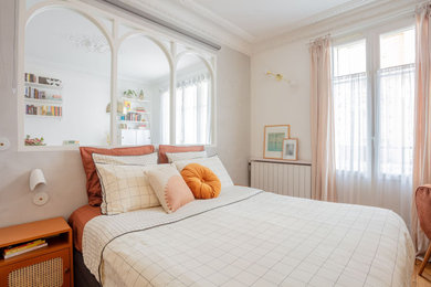 Modelo de dormitorio gris y blanco tradicional de tamaño medio sin chimenea con paredes blancas, suelo de madera clara y suelo marrón