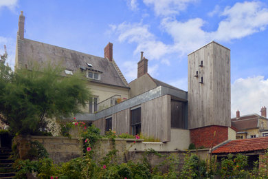 Imagen de fachada de casa de tamaño medio de una planta con revestimiento de madera y tablilla