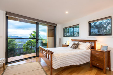 This is an example of a mid-sized traditional master bedroom in Hobart with white walls and medium hardwood floors.