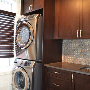 Modelo de lavadero lineal, actual, pequeño, con fregadero bajoencimera, armarios estilo shaker, puertas de armario de madera en tonos medios, encimera de cuarzo compacto, paredes blancas y lavadora y secadora apiladas