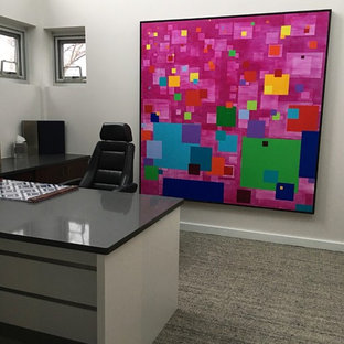 Large modern study in Chicago with white walls, carpet, no fireplace, a built-in desk and multi-coloured floors.
