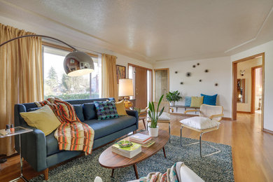 Example of a mid-sized 1960s enclosed medium tone wood floor and brown floor living room design in Portland with white walls