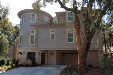 Example of a mid-sized classic beige two-story wood exterior home design in Charleston with a shingle roof