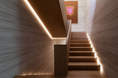 Diseño de escalera suspendida minimalista grande con escalones de madera, contrahuellas de madera y barandilla de madera