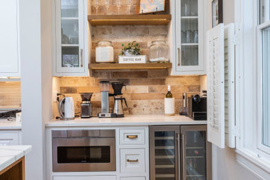 Example of a transitional light wood floor home bar design in Cincinnati with white cabinets, quartz countertops and white countertops