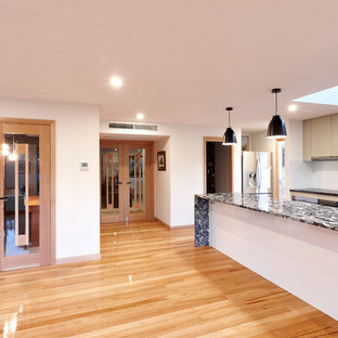 Mid-sized modern kitchen pantry photos - Example of a mid-sized minimalist kitchen pantry design in Hobart with open cabinets, white cabinets, granite countertops and stainless steel appliances