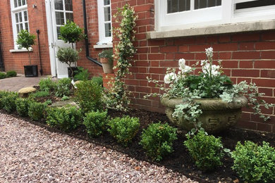 Photo of a medium sized classic courtyard formal partial sun garden for summer in Sussex with a potted garden and gravel.