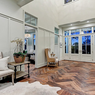 ロサンゼルスの巨大な両開きドアカントリー風おしゃれな玄関ロビー (白い壁、無垢フローリング、グレーのドア、茶色い床) の写真