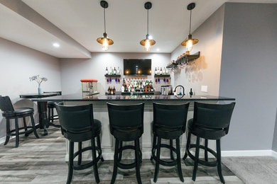 Mid-sized transitional u-shaped gray floor seated home bar photo in Chicago with an undermount sink, raised-panel cabinets, white cabinets, quartzite countertops and black countertops