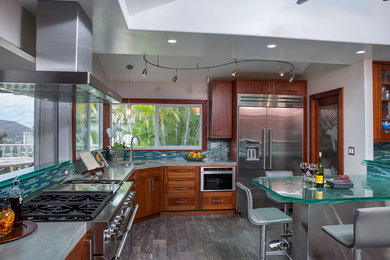 Inspiration for a large tropical porcelain tile eat-in kitchen remodel in Hawaii with an undermount sink, shaker cabinets, medium tone wood cabinets, concrete countertops, blue backsplash, glass tile backsplash, stainless steel appliances and no island