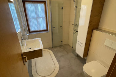 Modernes Duschbad mit Glasfronten, bodengleicher Dusche, Wandtoilette mit Spülkasten, Wandwaschbecken und Falttür-Duschabtrennung
