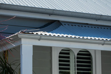 Small traditional one-storey grey house exterior in Sydney with a metal roof.