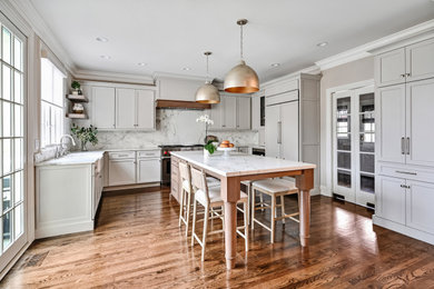 Inspiration for a transitional kitchen remodel in Chicago with flat-panel cabinets, marble countertops, stone slab backsplash, paneled appliances, an island and white countertops
