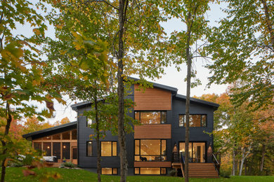 Example of a large transitional black two-story wood house exterior design in Other