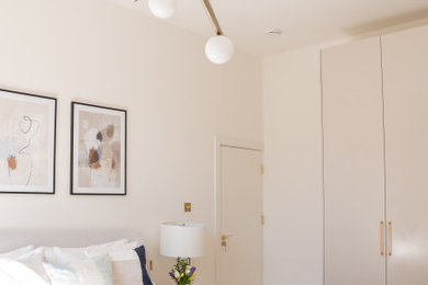 Cette photo montre une chambre parentale tendance de taille moyenne avec un mur beige, aucune cheminée et dressing.