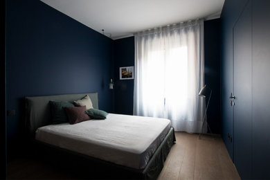 Immagine di una grande camera matrimoniale con pareti blu e parquet scuro