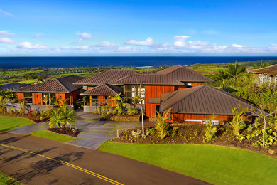 Photo of an expansive tropical two-storey brown house exterior in Hawaii with wood siding, a hip roof and a metal roof.