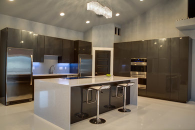 Eat-in kitchen - large modern l-shaped eat-in kitchen idea in Other with an undermount sink, flat-panel cabinets, gray cabinets, quartz countertops, stainless steel appliances, an island and gray backsplash