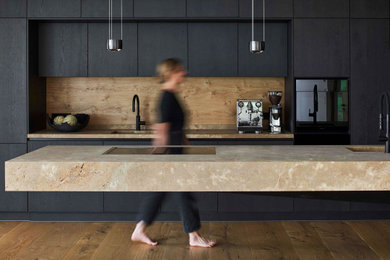 Geräumige Moderne Küche mit integriertem Waschbecken, flächenbündigen Schrankfronten, Granit-Arbeitsplatte, Rückwand aus Holz, gebeiztem Holzboden, Kücheninsel und brauner Arbeitsplatte in München