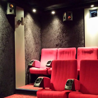 Inspiration for a modern enclosed carpeted and red floor home theater remodel in Nancy with black walls and a projector screen