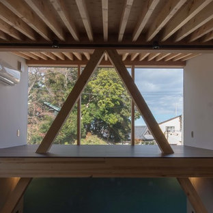 Esempio di una camera da letto stile loft etnica di medie dimensioni con pareti blu, pavimento in tatami, stufa a legna, cornice del camino in cemento e pavimento beige