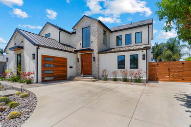 Large farmhouse white two-story exterior home idea in San Diego with a black roof